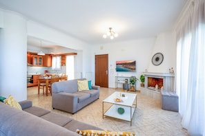 Ein modernes Wohnzimmer mit Sofa, Couchtisch und Kamin.