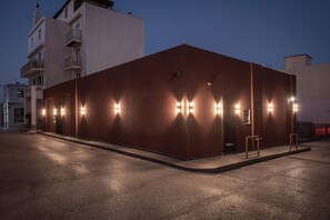 Un edificio con fachada plana y varios apliques a lo largo de un lateral.