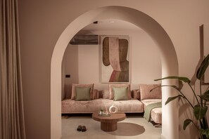 Ein modernes Interieur mit einer Sofagarnitur, einem Couchtisch und einem großen abstrakten Gemälde.