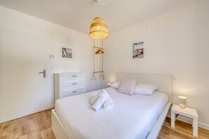 A bedroom with a bed, bedside table, and a hanging light fixture. - La Casa Romarin - Proche Libourne (Galgon)