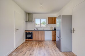 A compact kitchen with a built-in oven, dishwasher, and a refrigerator. - La Casa Romarin - Proche Libourne (Galgon)