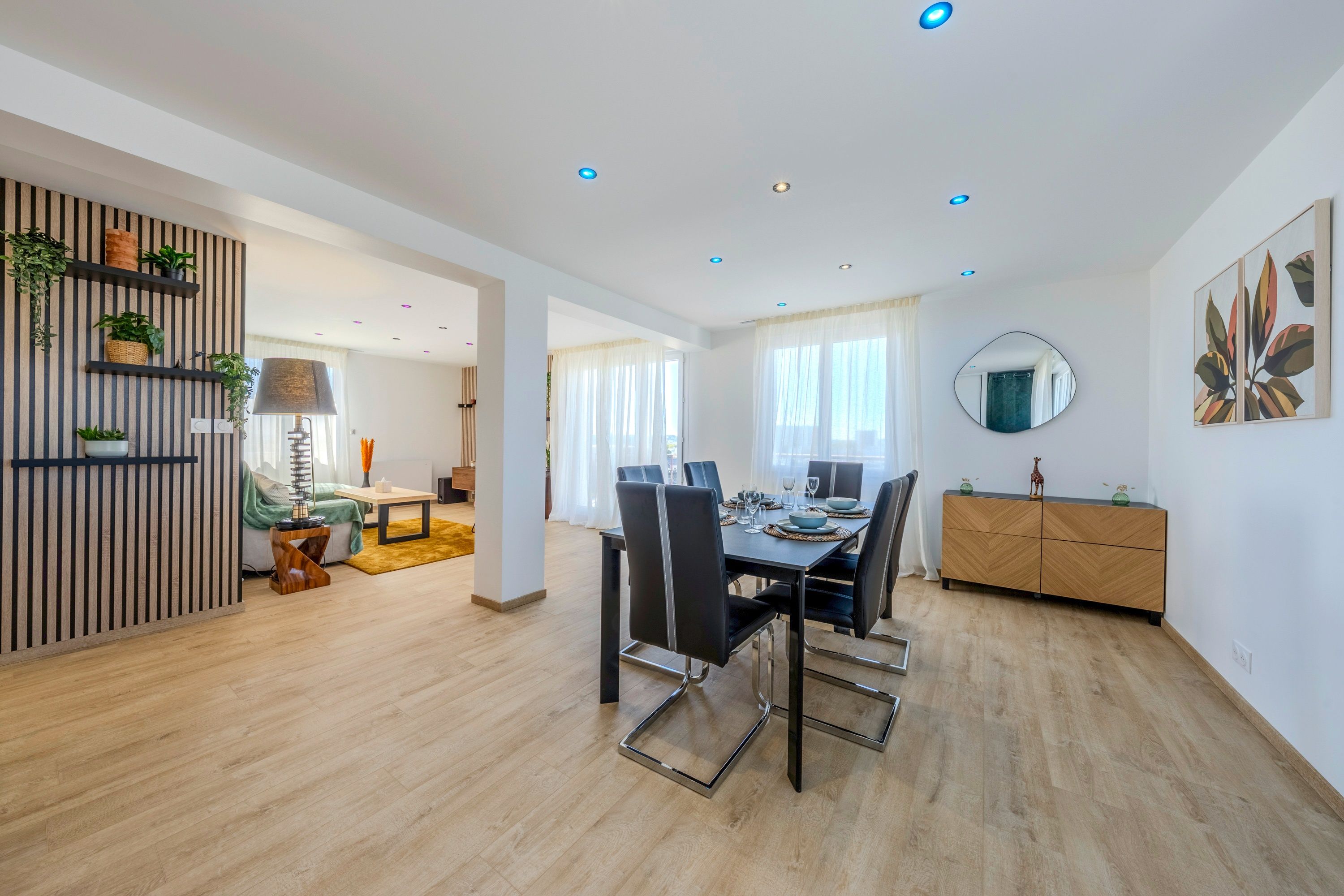 A modern living space with a dining area, a kitchen, and a seating area with a sofa and a coffee table.