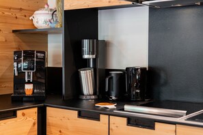 A modern kitchen with a coffee machine, a kettle, a thermos, and a teapot on the counter. - Chalet Casacamo - Chalet au pied des pistes (La Salle-les-Alpes)
