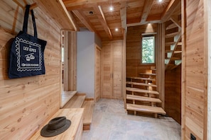 A wooden interior with a staircase, a bench, and a wall-mounted bag. - Chalet Casacamo - Chalet au pied des pistes (La Salle-les-Alpes)
