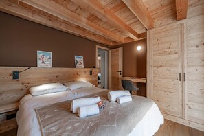 A wooden-paneled bedroom with a bed, a nightstand, and a wardrobe. - Chalet Casacamo - Chalet au pied des pistes (La Salle-les-Alpes)