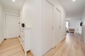 A spacious room with a large wardrobe, a small desk with a computer, and a view to the outside. - Le Mozart nancéen - proche du centre-ville (Nancy)