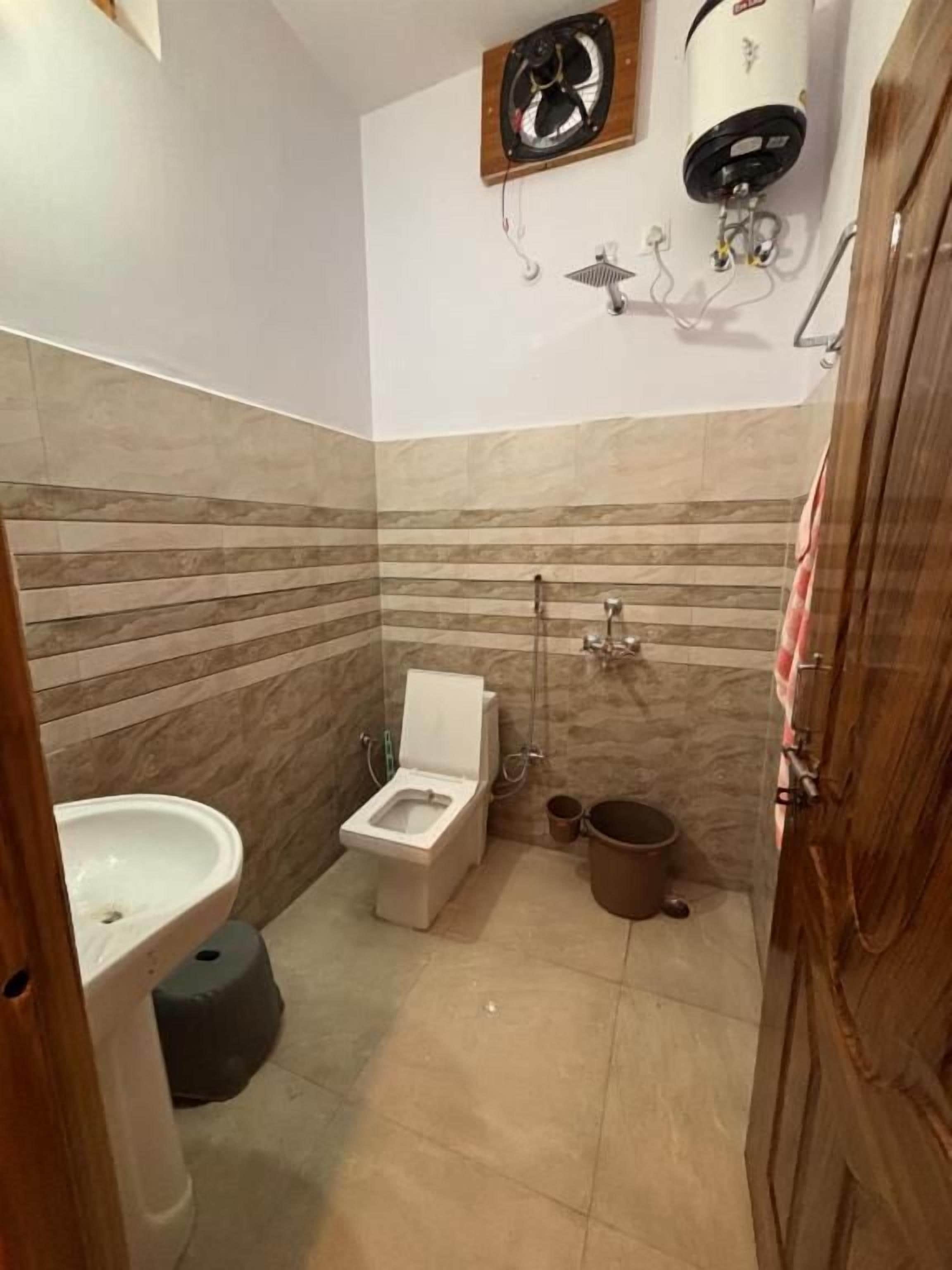 Un baño con inodoro, lavabo y ducha.