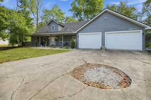 A two-story house with a garage, a driveway with a circular patch of gravel, and a lawn with trees. - Lake Cumberland Views, Hot Tub & Room for 11 (Somerset)