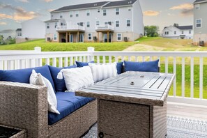 A wicker sofa with blue cushions and a matching table on a balcony with a white railing, overlooking a residential area. - 2 Back-to-Back Homes | Sleeps 18 | Near PSU (Bellefonte)
