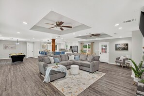 A spacious living room with a sectional sofa, a pool table, and ceiling fans. - Modern 3BR Oasis with Hot Tub and Pool Table (Abilene)