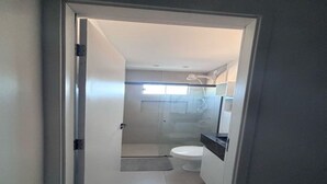Une salle de bain avec des toilettes, une douche et un lavabo.