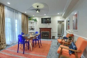 A dining area with a table and chairs, a fireplace, and a television mounted on the wall. - Minutes to Capitol & UPMC  Monthly w/ Parking. Perfect for Professionals; 2nd Fl (Harrisburg)