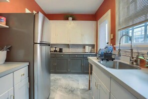 A kitchen with a stainless steel refrigerator, grey cabinets, a marble countertop, and a window with blinds. - Minutes to Capitol & UPMC  Monthly w/ Parking. Perfect for Professionals; 2nd Fl (Harrisburg)