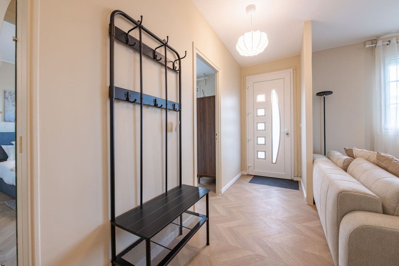 Un salon moderne avec un canapé, un banc et une étagère fixée au mur.