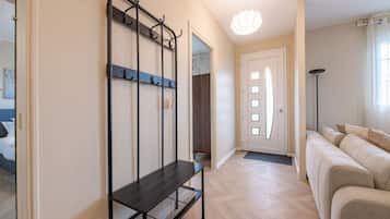A modern living room with a sofa, a bench, and a wall-mounted rack.