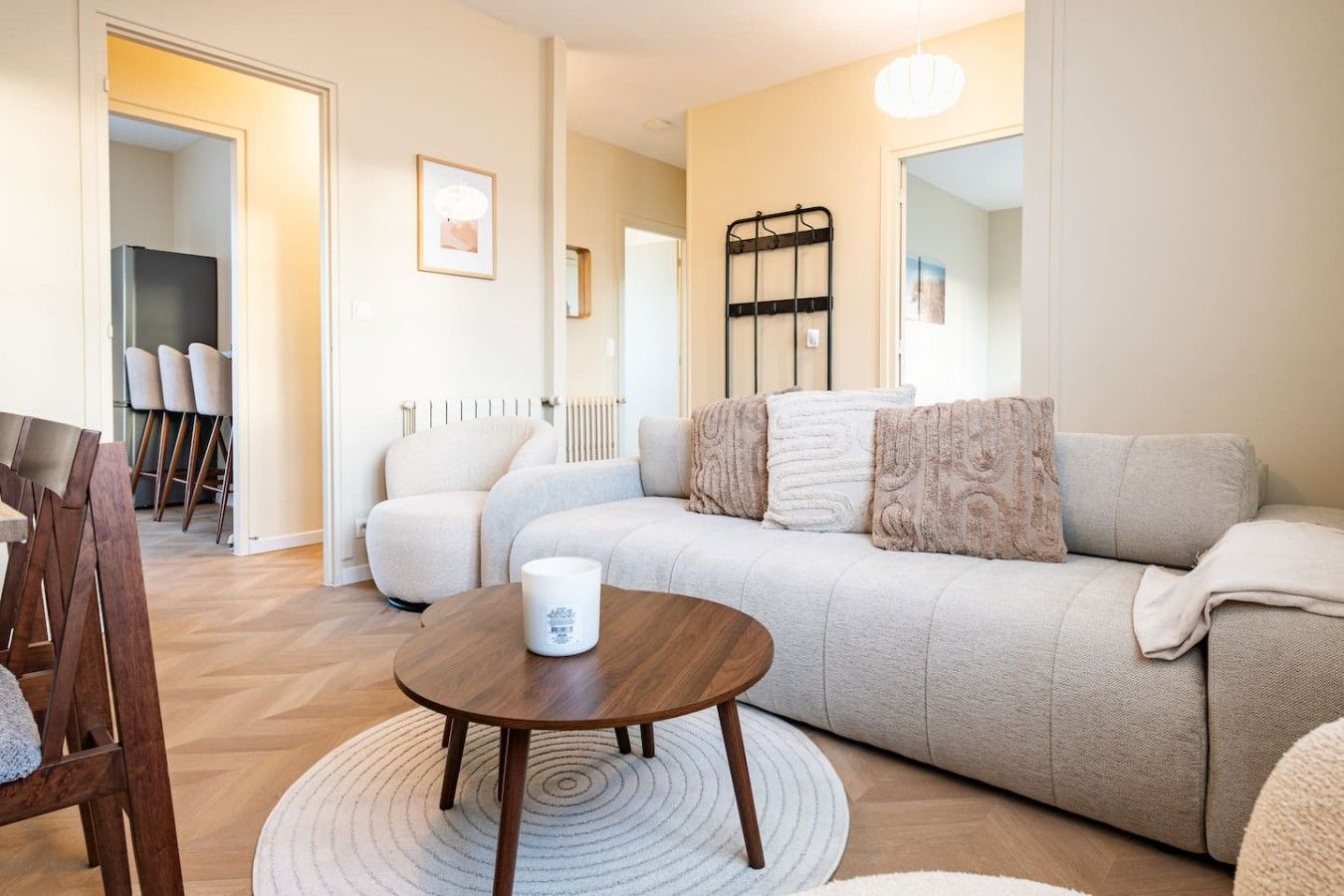 Un salon moderne comprenant un canapé, une table basse et un coin repas avec des chaises.