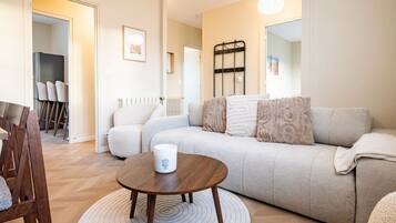 Un salon moderne comprenant un canapé, une table basse et un coin repas avec des chaises.