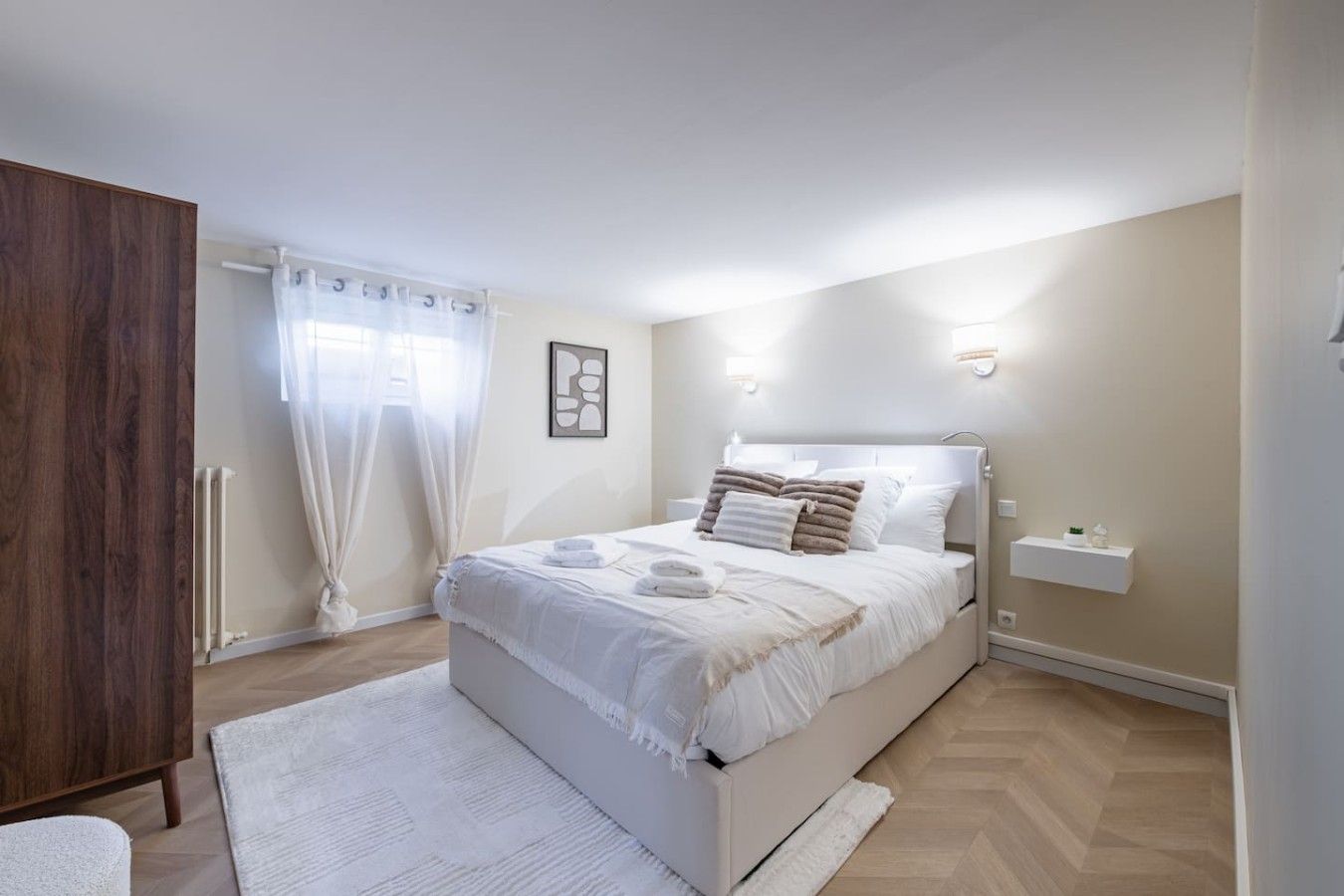 Una camera da letto con un letto, un comodino, un armadio e una finestra con tende.
