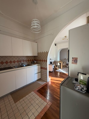 Eine moderne Küche mit weißen Schränken, einer gefliesten Spritzschutzwand und Holzboden.