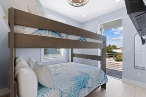 A bedroom with a bunk bed, a window with blinds, a ceiling light fixture, and a view of the outside. - 🐢The Turtle Nest | Private Heated Pool | Newly Built Home (Fort Myers beach)