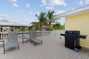 Eine Terrasse mit Sitzgelegenheiten und einem Grill.