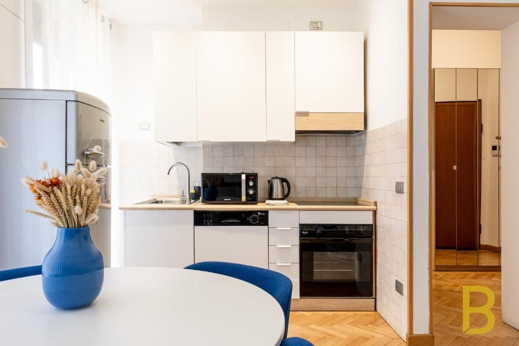A compact kitchen with white cabinets, a microwave, a coffee maker, and a dishwasher.
