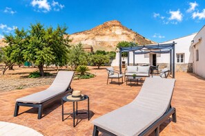 A patio with lounge chairs, a table, and a pergola. - Villa Milano – 4 bedroom house with private pool & garden in Lubrin (La Rambla Aljibe)