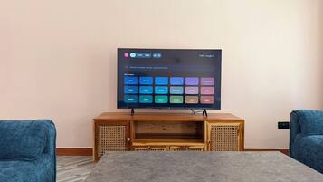 Ein Flachbildfernseher an der Wand, darunter eine Holzunterhaltungseinheit.