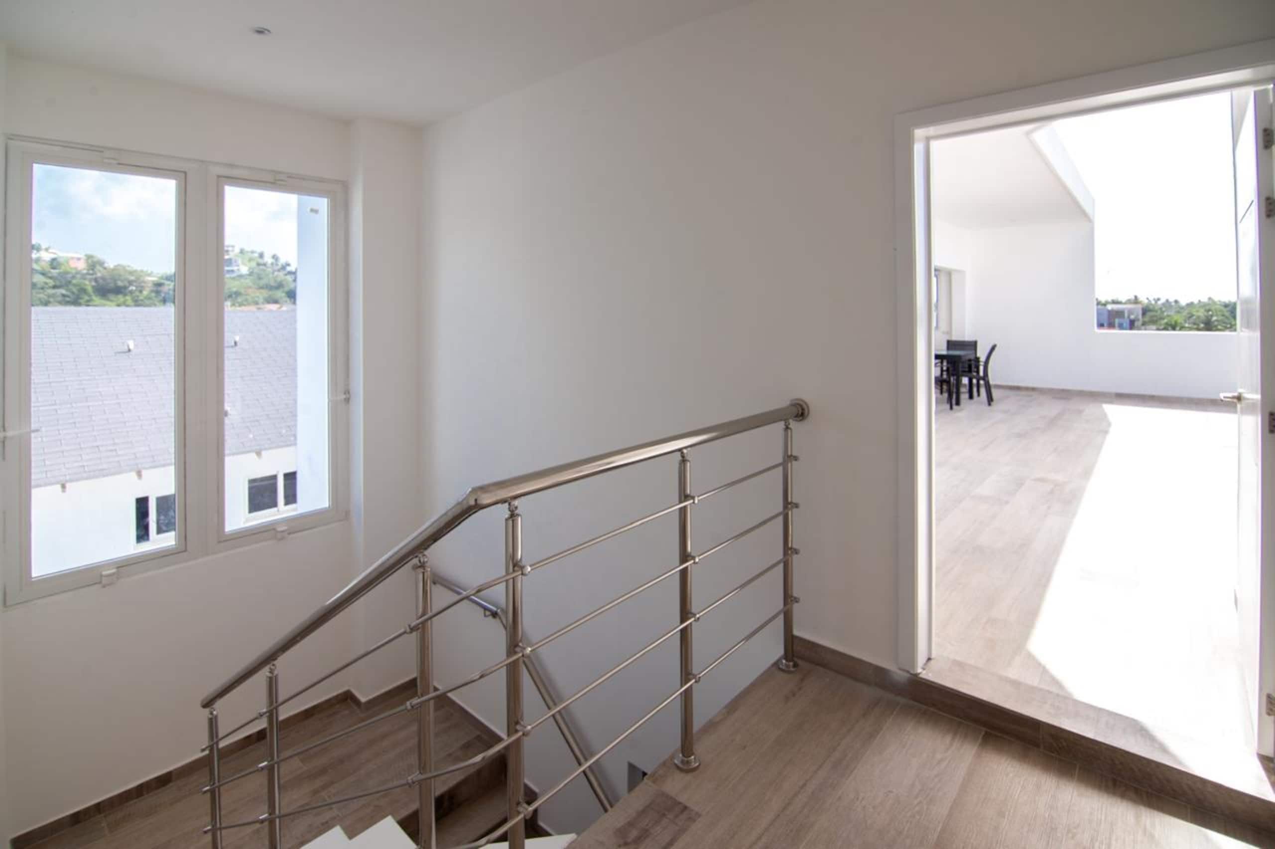 Eine Treppe mit Metallgeländern, die zu einer oberen Etage führt.