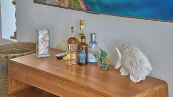Una mesa de madera con varias botellas y una escultura decorativa de un pez.