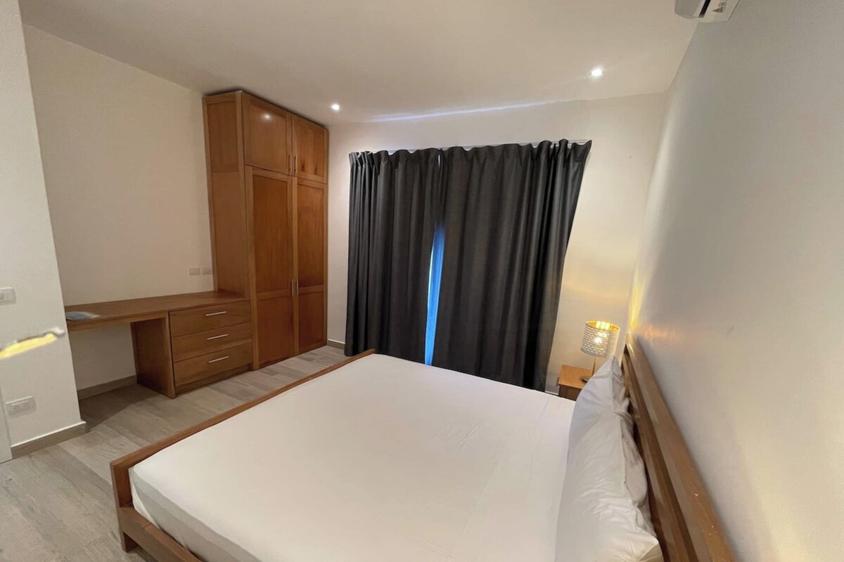 Un dormitorio con cama, escritorio y armario.