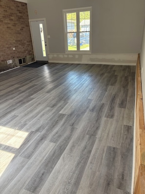 A spacious room with a large wooden floor, a door, and a window with a view of the outside. - Wake up to
Lake Erie (Bayham)