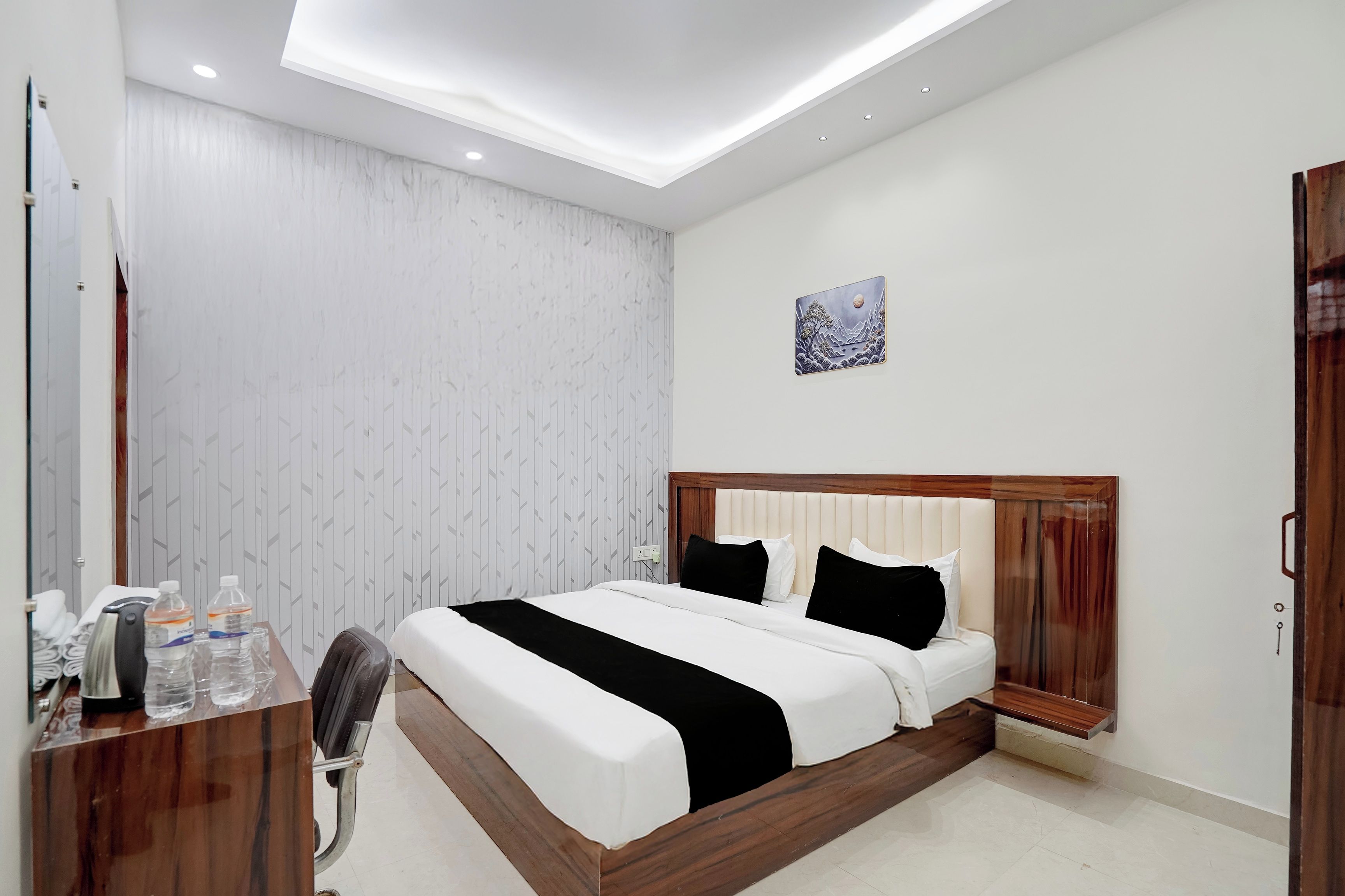 Una habitación de hotel moderna con cama, mesita de noche y armario.