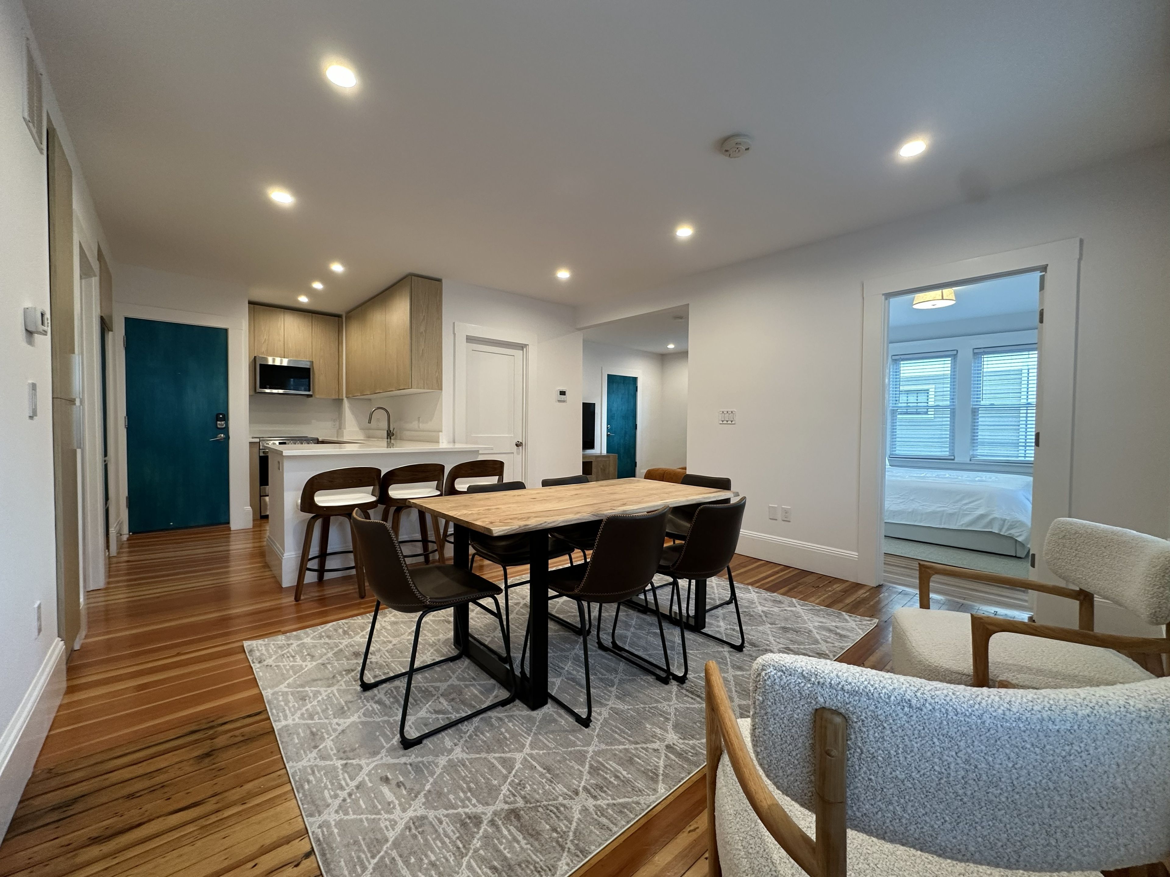 Een modern interieur met een eethoek, keuken en een groot raam.