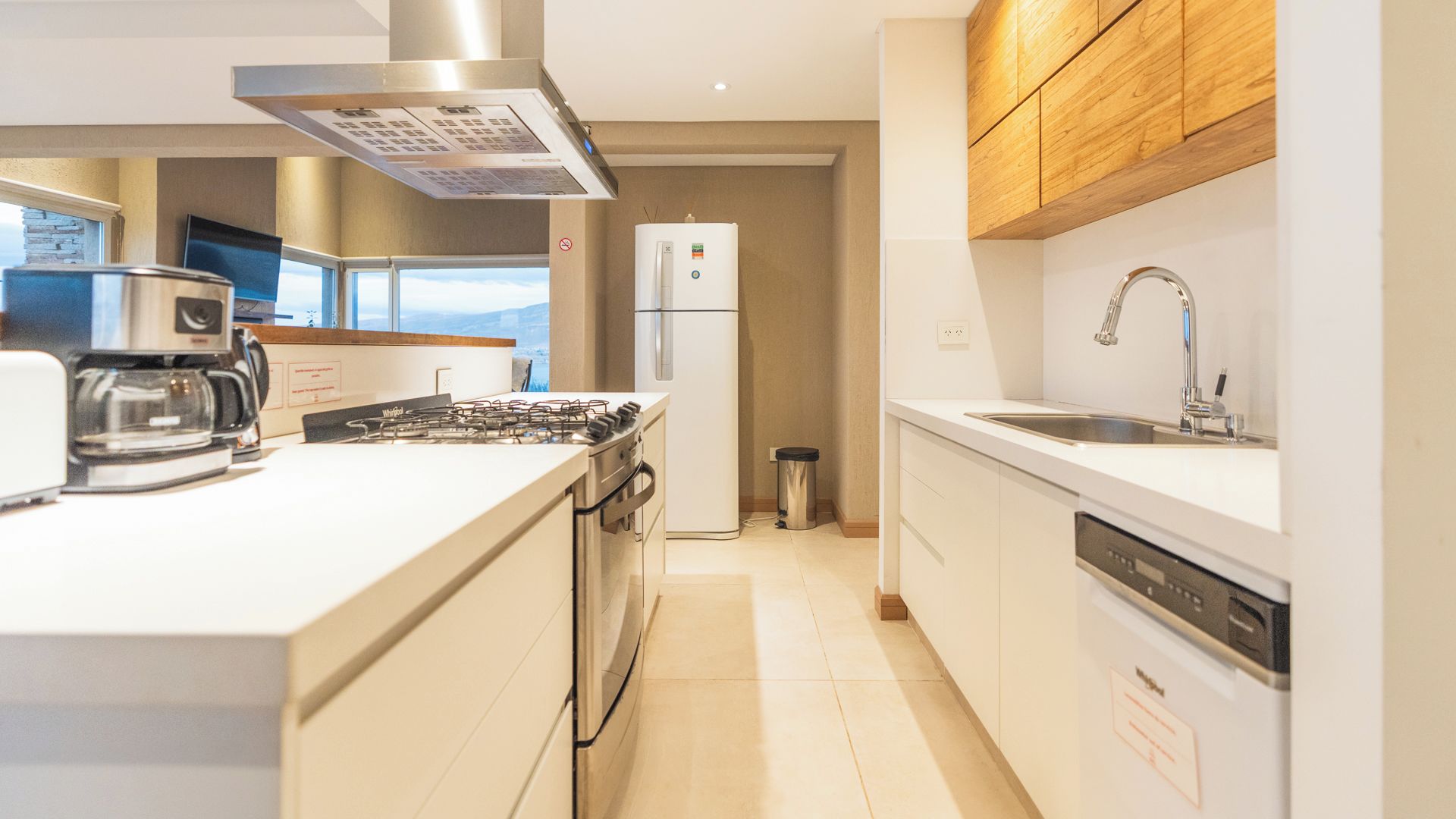 A modern kitchen with a gas stove, coffee maker, and a built-in dishwasher.