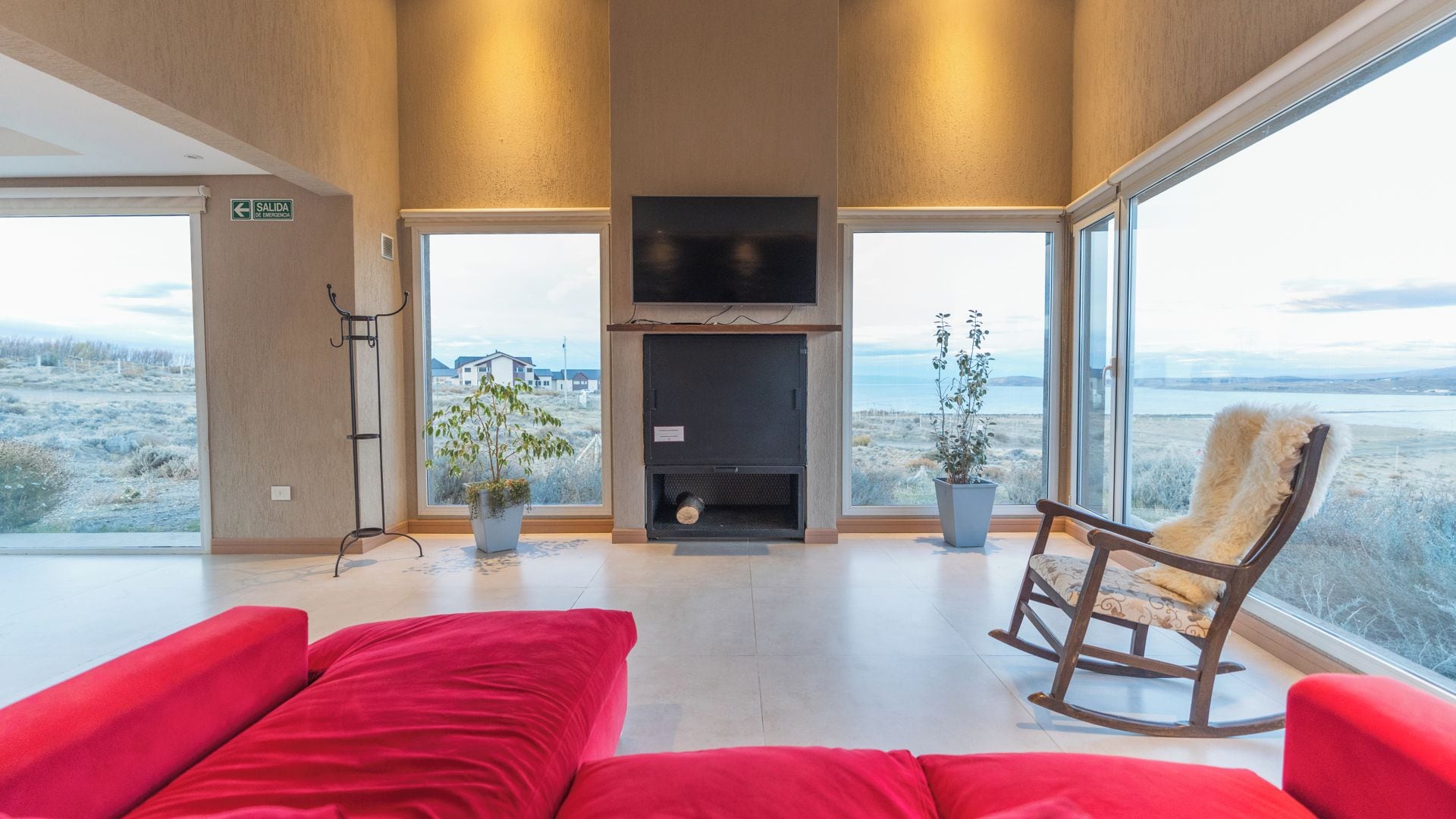 Ein modernes Interieur mit Kamin, Sitzgruppe und großen Fenstern mit Landschaftsblick.
