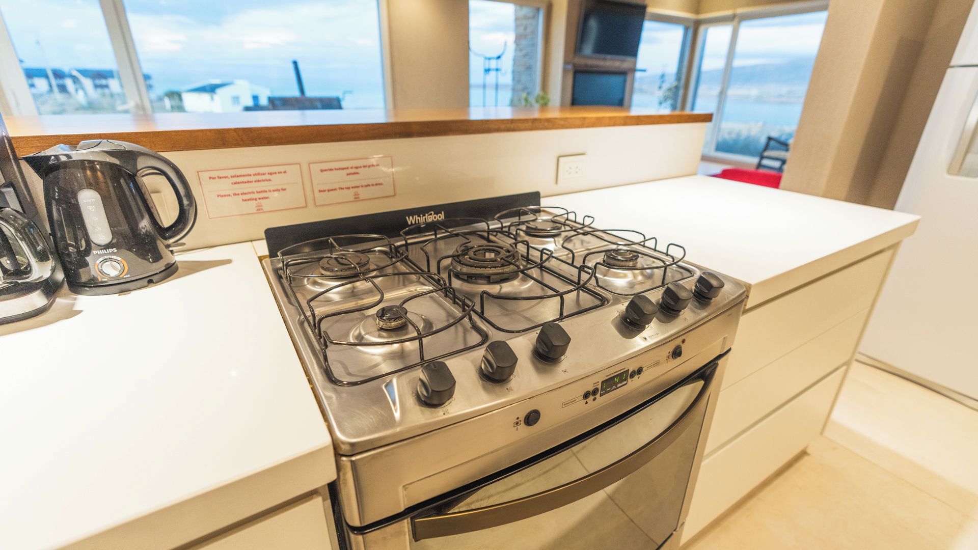 A modern kitchen with a gas stove, an oven, and a coffee maker.