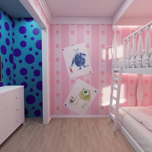 Ein Kinderzimmer mit Etagenbett, Kommode und Wand mit Zeichnungen.