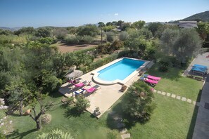 A rectangular swimming pool with a surrounding deck, surrounded by lush greenery and a few trees. - Holiday Home "Assumpcio" with Mountain View, Pool, Garden & Wi-Fi (Illes Balears)