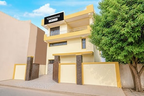 A two-story building with a sign reading 'TOUR HOUSE' and 'OYO-Serviced'. - Super Townhouse Sector 13 Gurgaon (Gurugram)