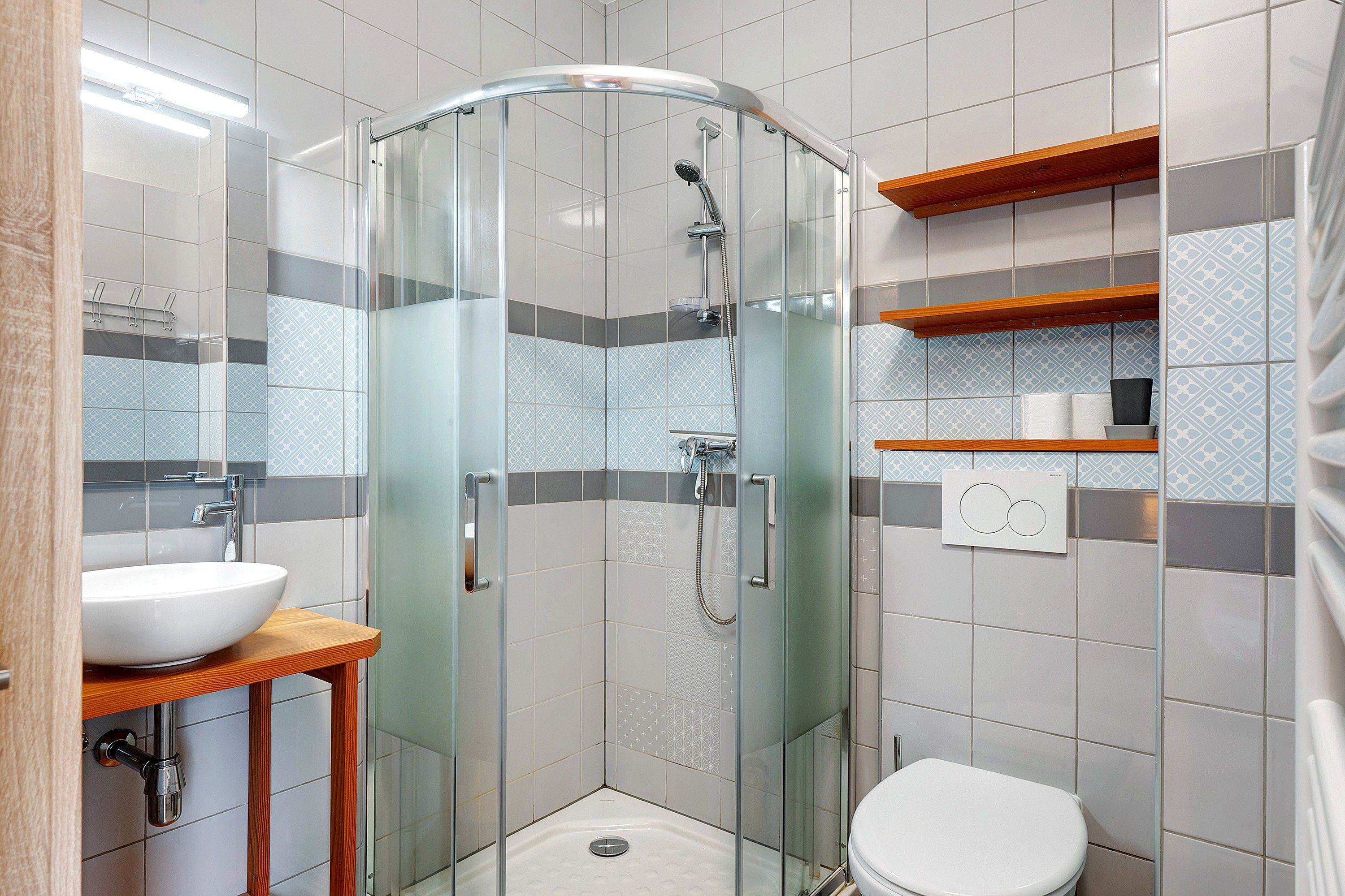 Une salle de bain moderne avec une douche à parois de verre, un lavabo blanc et des toilettes.
