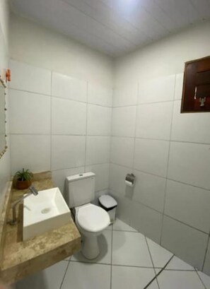 A small bathroom with a toilet, sink, and a mirror. - Vagner's house (Grajaú)