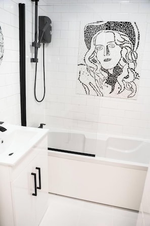 A modern bathroom with a white sink, a bathtub, and a shower area. - Cosy Flat in Prestwich, Sleeps 4, Spacious, Work, Getaway (Prestwich)