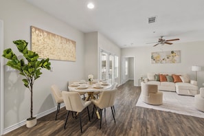 A modern living room with a dining area, a ceiling fan, and a large abstract painting. - Bright 2-bedroom apartment with AC in beautiful Dallas (Dallas)
