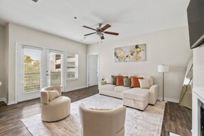 A spacious living room with a ceiling fan, a sofa set, a coffee table, and a fireplace. - Bright 2-bedroom apartment with AC in beautiful Dallas (Dallas)