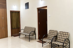 A room with two sofas and a wardrobe, a door, and a small window. - Reveridge Flora Cottage 3BH Matheran (Matheran)