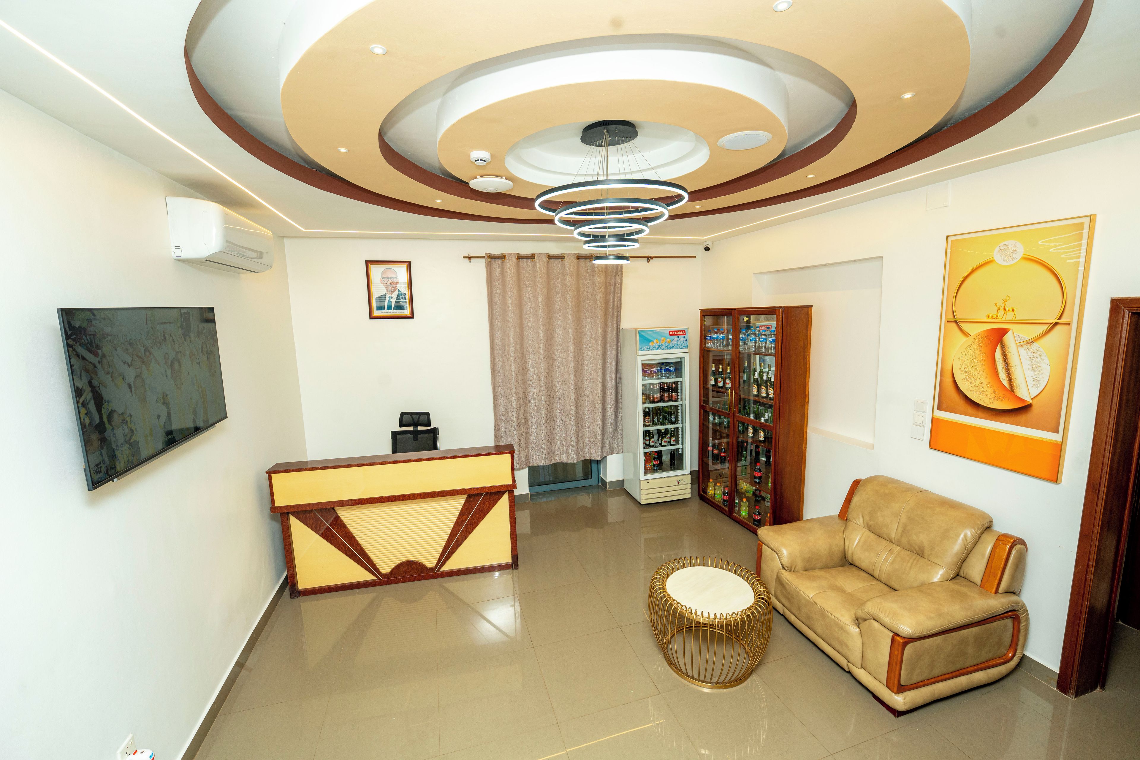 Un vestíbulo moderno con mostrador de recepción, zona de estar y techo decorativo.
