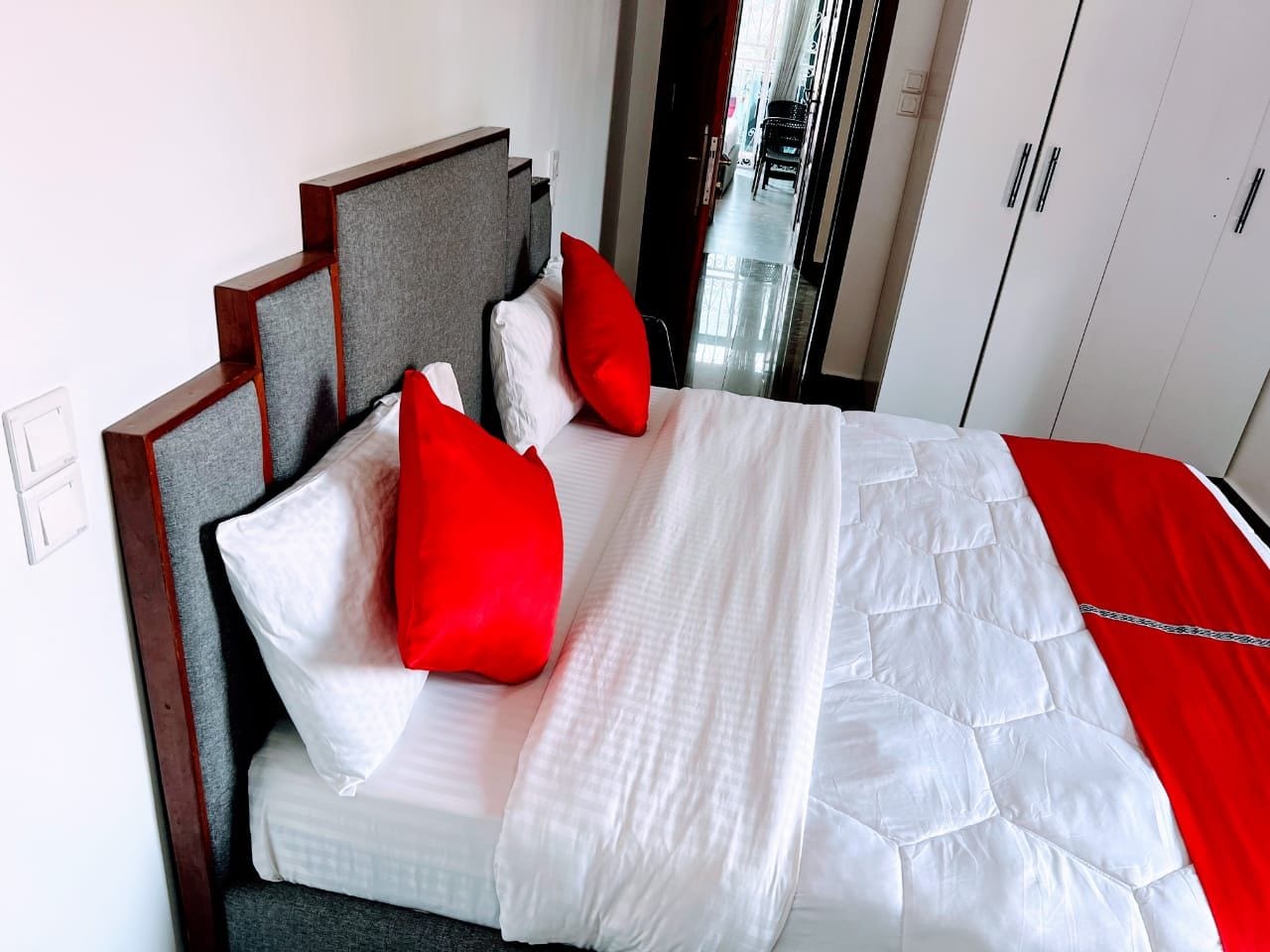 Habitació d'hotel amb llit, capçalera i armari.