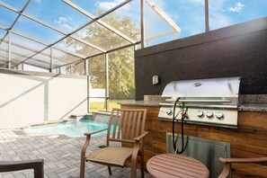 An outdoor patio with a pool, a grill, and seating. - 4BR Near Disney Private Pool, Themed Rooms (Kissimmee)