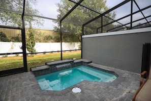 A covered outdoor swimming pool with a view of the backyard. - 4BR Themed Townhouse Pool Near Disney (Kissimmee)